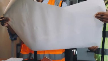 Fabrikada pano tutan beyaz üniformalı bir işçi.