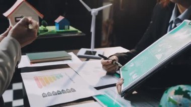 İşletme ekibi yeşil grafikle birlikte dizüstü bilgisayarla proje üzerinde çalışıyor.