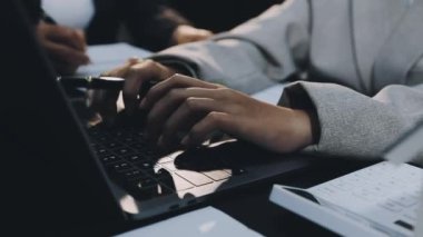 Ofiste çalışırken dizüstü bilgisayar kullanan genç iş adamının resmini kapat