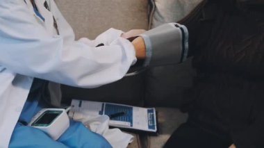 Doktor hastanın kan basıncını ölçüyor.