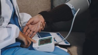 Doktor hastanın elini tutuyor.