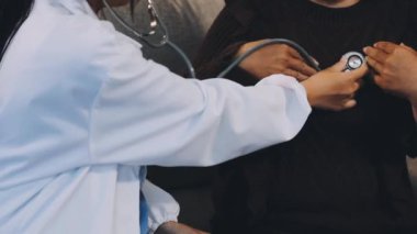 Doktor genç bayanın tansiyonunu ölçüyor.