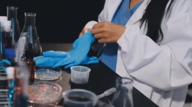 Laboratuvarda kimyasal deney yapan genç bir bilim kadını.