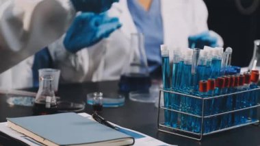 Laboratuvarda deney tüpü ve test tüpü olan bir deney tüpü tutan bilim adamı..