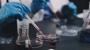 Laboratuvarda elinde sıvı olan bir matarayı tutan bilim adamı.