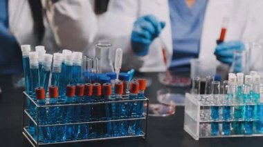 Laboratuvar asistanı laboratuarda test tüpü ve kimyasal örnek tutuyor.