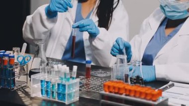 Kadın bilim adamı elinde sıvı test tüpü tutuyor.