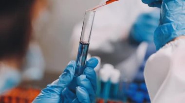 Yakın plan. Elinde sıvı olan bir test tüpü tutan bir kadın doktor.
