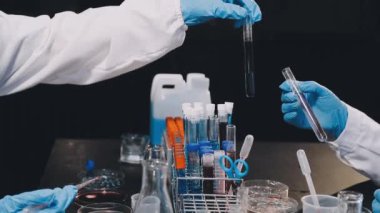 Laboratuvarda sıvı içeren bir matarayı tutan bilim adamı.