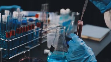 Laboratuvar asistanı laboratuvarda kimyasal bir sıvıyı test ediyor..
