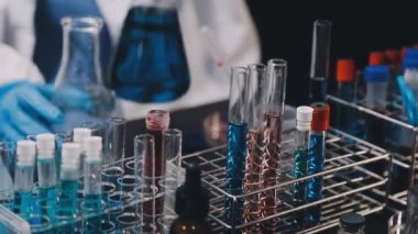 Laboratuvar asistanı laboratuarda tüp tutuyor.