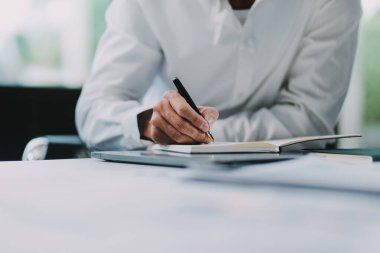 Bütçe, gelir, vergi ve iş büyümesini hesaplamak için hesap makinesini kullanırken, iki işadamı birlikte çalışarak mali raporları grafikler ve grafiklerle analiz ediyorlar. Girişim iş fikri.