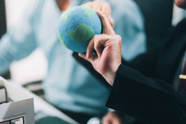 Rüzgar türbini modeli ve ev modeli için mühendisler buluşuyor. Yenilenebilir enerji ve konut geliştirme kavramı. Modern ofiste mimarlardan ve mühendislerden oluşan bir ekip tasarım yapısını tartışıyor..