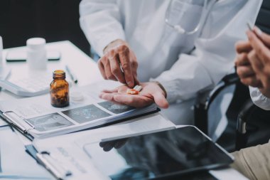 Bir grup pratisyen hekim hastanede birlikte çalışıyor ve tıbbi taramaları analiz ediyor.