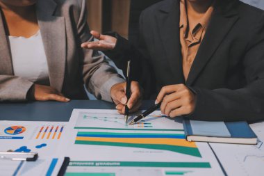 İş adamlarından oluşan bir ekip, pazarlama planı, piyasa araştırma raporları ve gelir istatistikleri, Mali ve Muhasebe kavramının verilerini analiz etmek üzere toplanıyor..