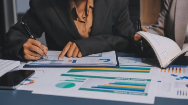 İş adamlarından oluşan bir ekip, pazarlama planı, piyasa araştırma raporları ve gelir istatistikleri, Mali ve Muhasebe kavramının verilerini analiz etmek üzere toplanıyor..