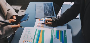 İş adamlarından oluşan bir ekip, pazarlama planı, piyasa araştırma raporları ve gelir istatistikleri, Mali ve Muhasebe kavramının verilerini analiz etmek üzere toplanıyor..