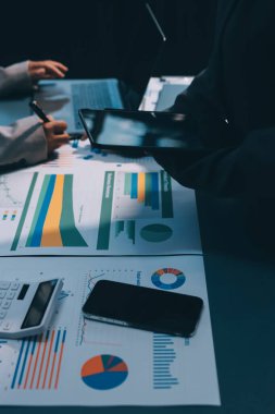 İş adamlarından oluşan bir ekip, pazarlama planı, piyasa araştırma raporları ve gelir istatistikleri, Mali ve Muhasebe kavramının verilerini analiz etmek üzere toplanıyor..