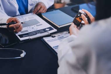 Güvenilir temsilci eczacılık hastanedeki doktor ve hemşire ekibine yeni ilaçlar gösteriyor. Bir grup doktora ilaç şişesini gösteren ve ilaç dozajını açıklayan yetişkin bir uzman..