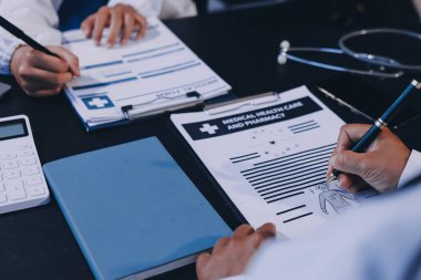 Güvenilir temsilci eczacılık hastanedeki doktor ve hemşire ekibine yeni ilaçlar gösteriyor. Bir grup doktora ilaç şişesini gösteren ve ilaç dozajını açıklayan yetişkin bir uzman..