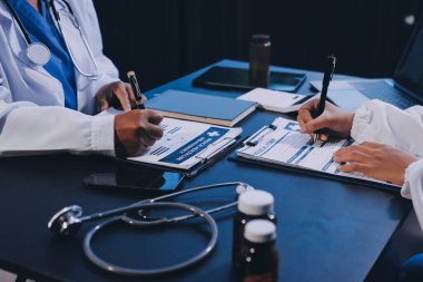 Güvenilir temsilci eczacılık hastanedeki doktor ve hemşire ekibine yeni ilaçlar gösteriyor. Bir grup doktora ilaç şişesini gösteren ve ilaç dozajını açıklayan yetişkin bir uzman..