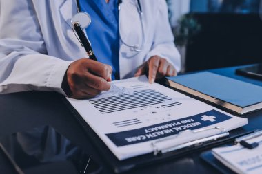 Güvenilir temsilci eczacılık hastanedeki doktor ve hemşire ekibine yeni ilaçlar gösteriyor. Bir grup doktora ilaç şişesini gösteren ve ilaç dozajını açıklayan yetişkin bir uzman..