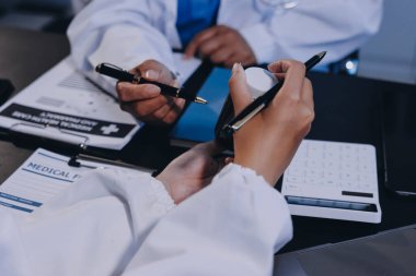 Güvenilir temsilci eczacılık hastanedeki doktor ve hemşire ekibine yeni ilaçlar gösteriyor. Bir grup doktora ilaç şişesini gösteren ve ilaç dozajını açıklayan yetişkin bir uzman..