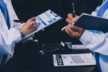 Dijital tablet sağlık doktoru teknolojisi tableti üzerinde çalışan tıbbi ekip hastanedeki tıbbi raporların sonuçlarını analiz etti..