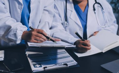 Dijital tablet sağlık doktoru teknolojisi tableti üzerinde çalışan tıbbi ekip hastanedeki tıbbi raporların sonuçlarını analiz etti..