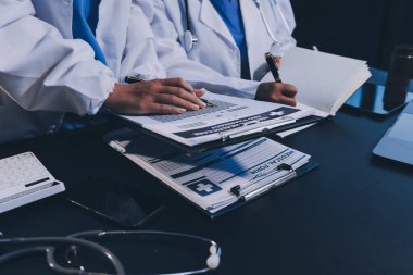 Dijital tablet sağlık doktoru teknolojisi tableti üzerinde çalışan tıbbi ekip hastanedeki tıbbi raporların sonuçlarını analiz etti..