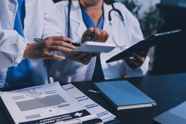 Dijital tablet sağlık doktoru teknolojisi tableti üzerinde çalışan tıbbi ekip hastanedeki tıbbi raporların sonuçlarını analiz etti..