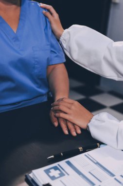 Nazik erkek doktor, beyaz önlüklü danışman yaşlı kadın hasta yaşlı kadının elini tutuyor. Yardım, güvenlik, empati ve destek veriyor, özen ve şefkat gösteriyor. Görüntüyü kapat