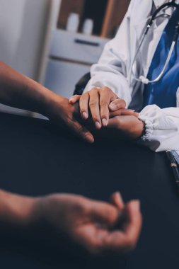 Nazik erkek doktor, beyaz önlüklü danışman yaşlı kadın hasta yaşlı kadının elini tutuyor. Yardım, güvenlik, empati ve destek veriyor, özen ve şefkat gösteriyor. Görüntüyü kapat