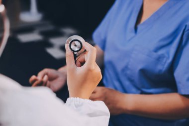 Kadın doktor kaba kalp atışı incelemek için stetoskop kullanın