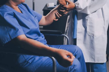 Doktor ya da fizyoterapist, sporcu erkek hastaların yaralı kollarını tedavi ediyor, esneme ve egzersiz yapıyor, klinikte rehabilitasyon tedavisi uyguluyor..