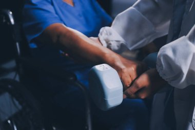 Evde dambıl kullanarak fizyoterapist eğitimi alan yaşlı bir kadın. Terapist, huzurevi egzersizlerinde yaşlı kadına yardım ediyor. Yaşlı bir hasta kollarını uzatmış halterler kullanıyor..