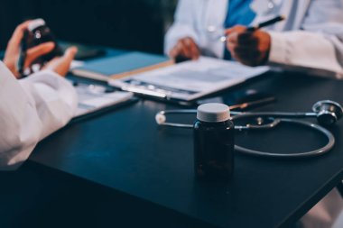 Güvenilir temsilci eczacılık hastanedeki doktor ve hemşire ekibine yeni ilaçlar gösteriyor. Bir grup doktora ilaç şişesini gösteren ve ilaç dozajını açıklayan yetişkin bir uzman..