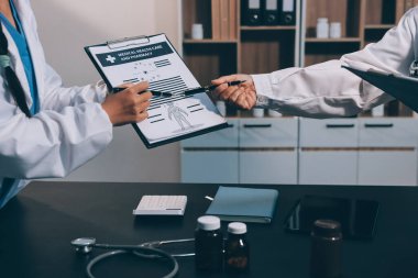 Hastane tıbbı çok etik insanlar grup toplantısı ekibi, aşı eğitimi için hemşire öğrencilerle klinik odasında konuşma. Tablet ve pano tutuluyor.