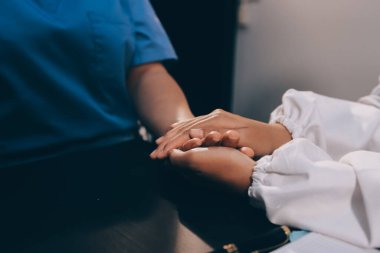 Nazik erkek doktor, beyaz önlüklü danışman yaşlı kadın hasta yaşlı kadının elini tutuyor. Yardım, güvenlik, empati ve destek veriyor, özen ve şefkat gösteriyor. Görüntüyü kapat