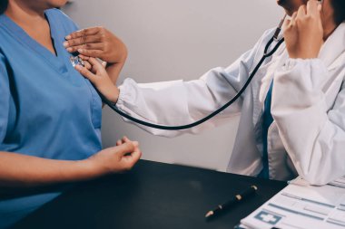 Kadın doktor kaba kalp atışı incelemek için stetoskop kullanın