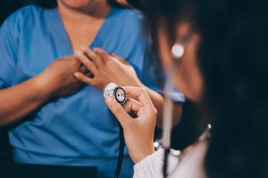 Kadın doktor kaba kalp atışı incelemek için stetoskop kullanın