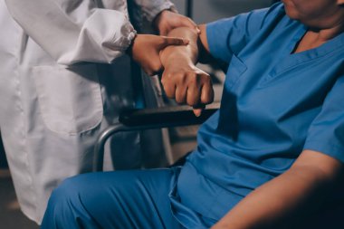 Doktor ya da fizyoterapist, sporcu erkek hastaların yaralı kollarını tedavi ediyor, esneme ve egzersiz yapıyor, klinikte rehabilitasyon tedavisi uyguluyor..