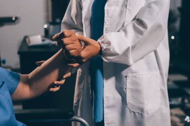 Doktor ya da fizyoterapist, sporcu erkek hastaların yaralı kollarını tedavi ediyor, esneme ve egzersiz yapıyor, klinikte rehabilitasyon tedavisi uyguluyor..