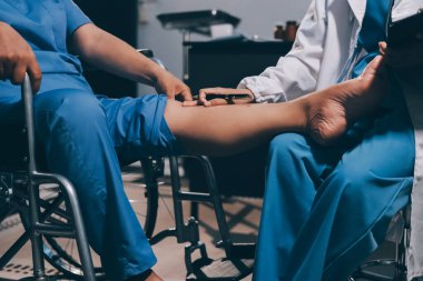 Yaşlı kadın hastanın bacağını iyileştirmek için fizyoterapi yapan fizyoterapist hemşire..