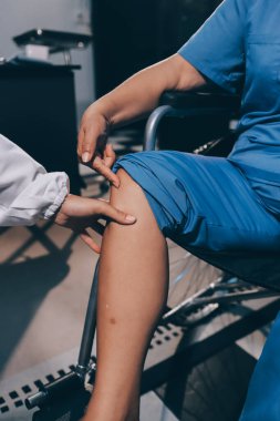 Yaşlı kadın hastanın bacağını iyileştirmek için fizyoterapi yapan fizyoterapist hemşire..