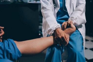 Yaşlı kadın hastanın bacağını iyileştirmek için fizyoterapi yapan fizyoterapist hemşire..