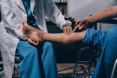 Yaşlı kadın hastanın bacağını iyileştirmek için fizyoterapi yapan fizyoterapist hemşire..