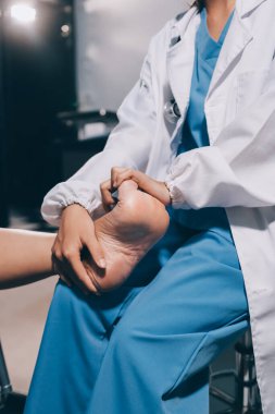 Yaşlı kadın hastanın bacağını iyileştirmek için fizyoterapi yapan fizyoterapist hemşire..