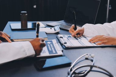 Güvenilir temsilci eczacılık hastanedeki doktor ve hemşire ekibine yeni ilaçlar gösteriyor. Bir grup doktora ilaç şişesini gösteren ve ilaç dozajını açıklayan yetişkin bir uzman..