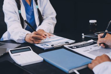 Güvenilir temsilci eczacılık hastanedeki doktor ve hemşire ekibine yeni ilaçlar gösteriyor. Bir grup doktora ilaç şişesini gösteren ve ilaç dozajını açıklayan yetişkin bir uzman..